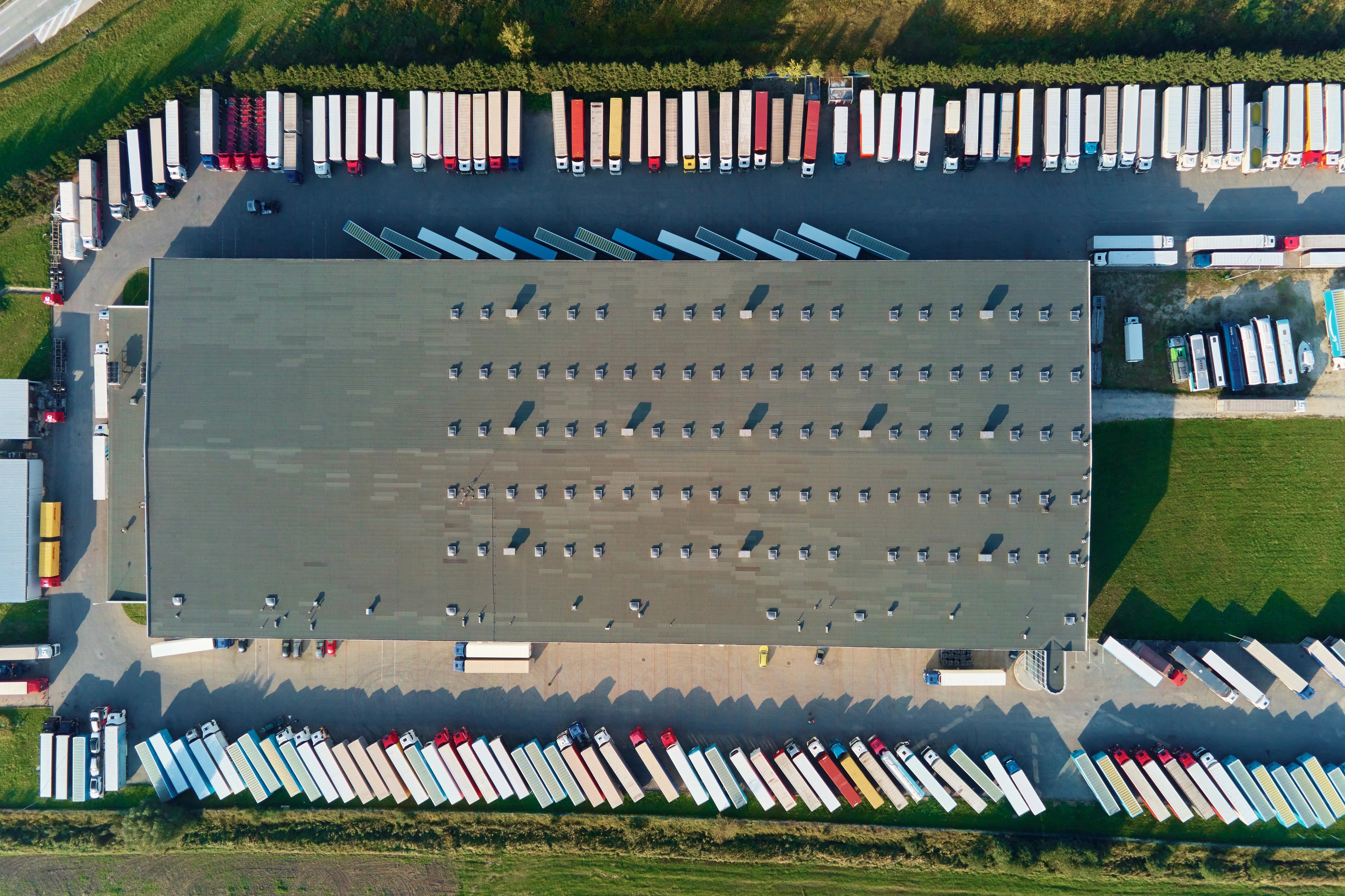 Aerial view of commercial freight trailers positioned around a logistics warehouse