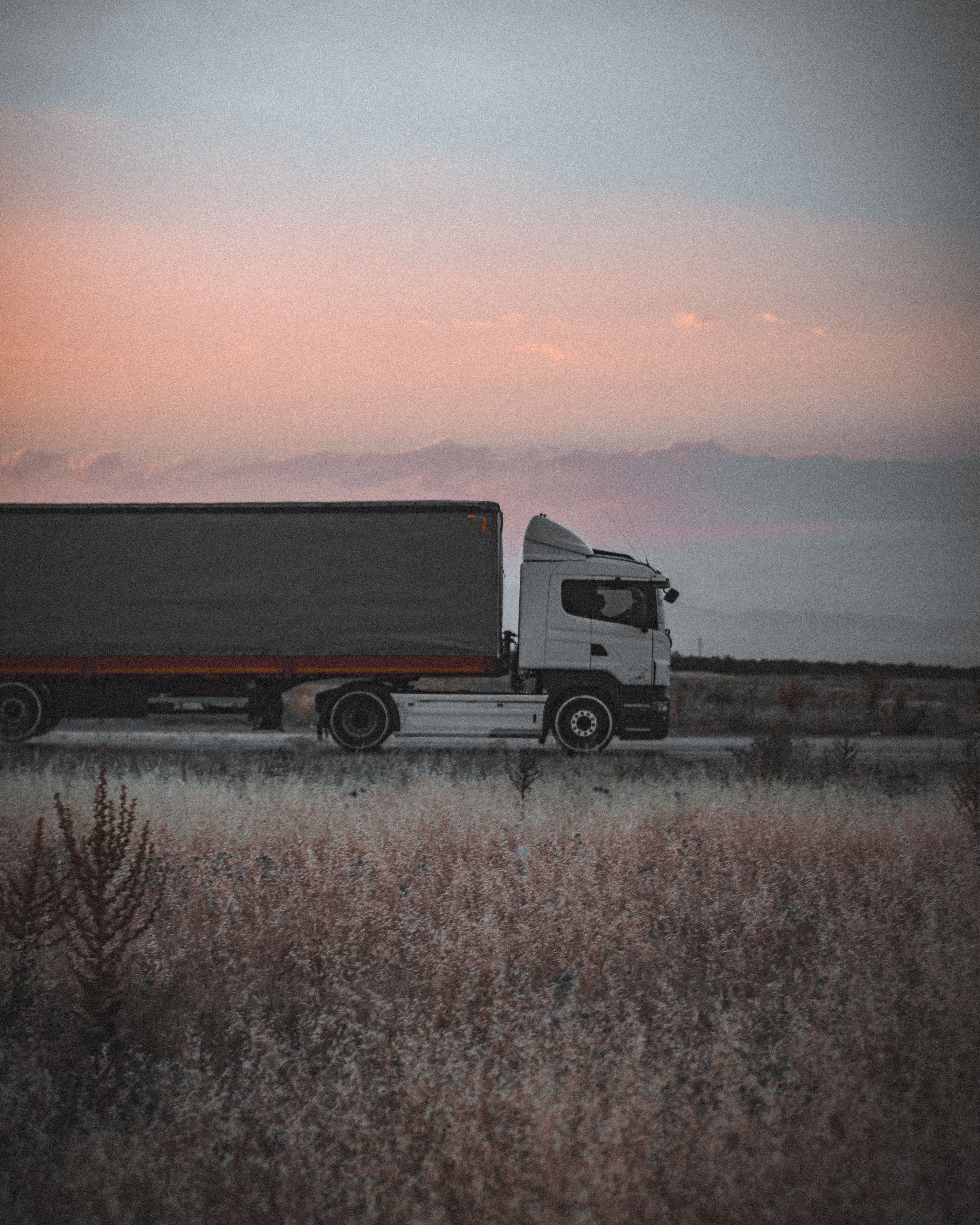 White semi tractor-trailer hauling freight on an open highway